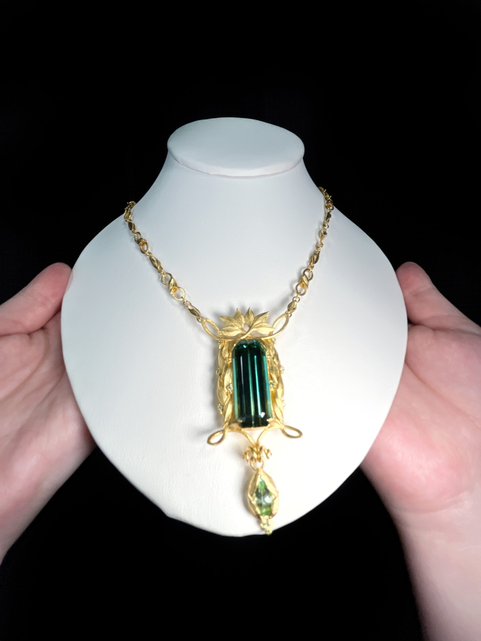 22K yellow gold Gary Roe Jewelry necklace featuring a 33 ct. bicolor Tourmaline, pear-shape Tourmaline, and Tsavorite Garnets.